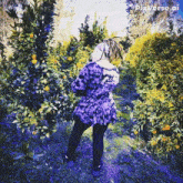 a woman in a purple dress stands in a field of trees with pixverse.ai in the corner