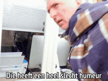a man standing in front of a computer with the words die heeft een heel slecht humeur
