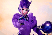 a drag queen in a purple outfit is holding a planet in her hand