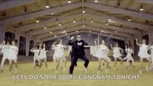 a man in a suit is dancing in front of a group of dancers .