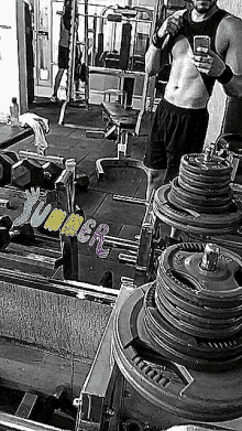 a man is taking a picture of his torso in a gym with the words summer written on the floor