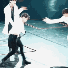 a blurry photo of two men dancing on a stage with the words skiosim visible