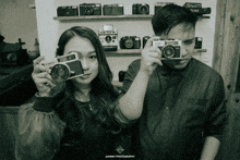 a man and a woman holding cameras with johnny photography written on the bottom right corner