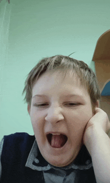 a young boy making a funny face with his tongue sticking out