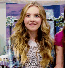 a woman with long blonde hair is smiling and saying yay