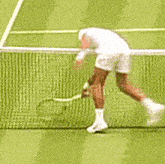 a tennis player is bending over to pick up his tennis racket