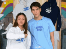 a man and a woman standing next to each other wearing kobie andi tshirts