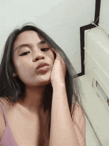 a woman in a purple tank top takes a selfie