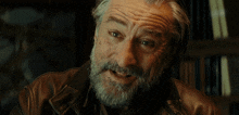 a man with gray hair and a beard is wearing a leather jacket
