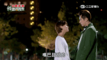 a man in a green jacket kisses a woman in a white shirt