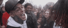 a man is laughing in front of a crowd of people .