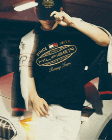 a man wearing a tommy hilfiger racing team t-shirt