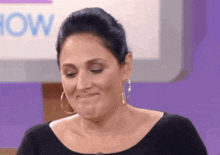 a woman making a funny face in front of a sign that says show