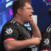 a man wearing a black shirt with the word steelseries on the sleeves