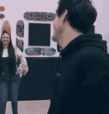 a man and woman are standing in front of a wall with skateboards on it .