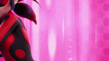 a ladybug from miraculous ladybug is standing in front of a pink curtain .