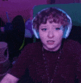 a woman wearing headphones is making a funny face while sitting in front of a computer .