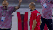 a man wearing a red shirt with the number 11 on the back is walking