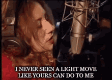 a woman singing into a microphone with a caption that says " i never seen a light move like yours can do to me "