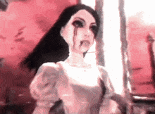 a woman with blood dripping from her eyes and a white dress