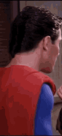 a close up of a man in a superman costume looking down .