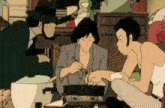 a group of people are sitting around a table eating food from a pot .