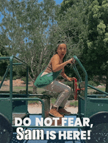 a woman in a green vehicle with the words do not fear sam is here below her