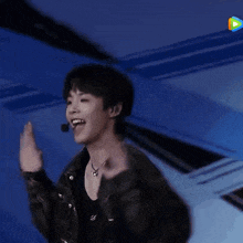 a young man is dancing on a stage with a microphone .
