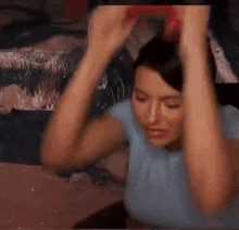 a woman is holding her hands up in the air while sitting in front of a piano .