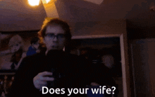a man with glasses is holding a microphone and asking does your wife