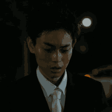 a man in a suit and tie looks at the camera with a serious look on his face
