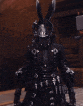 a person wearing a black armor with a shield on their chest