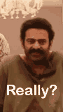 a man with a beard and mustache is standing in front of a sign that says `` really '' .