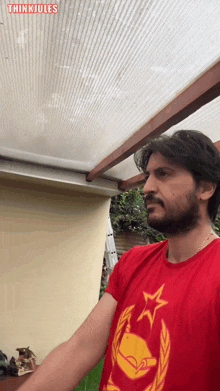 a man wearing a red shirt with a yellow star on it