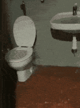 a bathroom with a toilet and a sink with water running out of the sink