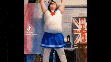 a woman in a sailor moon costume is dancing in a room with a british flag in the background .