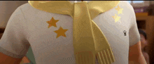 a close up of a person wearing a yellow scarf and a white shirt with two yellow stars on it .