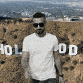 a man standing in front of a hollywood sign