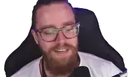 a man with a beard wearing glasses is sitting in a chair