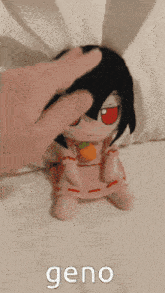 a stuffed animal with a carrot in its mouth is being petted by a hand .