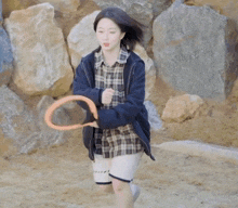 a girl in a plaid shirt and shorts is playing tennis