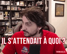 a man wearing a red shirt with the words il s'attendait a quoi on it