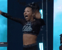 a cheerleader is wearing a black top that says elite