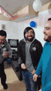 a group of men are standing in a living room with balloons on the ceiling .