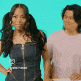 a woman in a denim dress stands next to a man in a pink shirt with flighthouse written on the bottom right