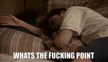 a man laying on a bed with the words " whats the fucking point " below him