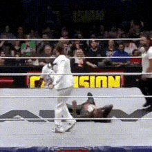 a man in a white shirt is standing in a wrestling ring with a sign that says ' reign ' on it