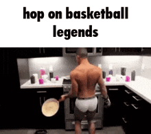 a shirtless man is standing in a kitchen holding a pan and a pancake .