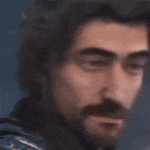 a close up of a man 's face with a beard looking at the camera