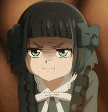 a little girl with green eyes and a bow on her head makes an angry face